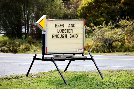 marquee on a roadside with attention-grabbing copywriting with text 'beer and lobster enough said'.
