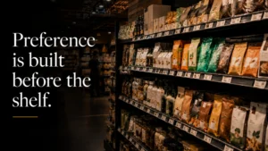 A warm, cinematic supermarket shelf scene showing multiple competing consumer products, with a dark overlay and the message “Preference is built before the shelf,” connecting UX strategy and content marketing to how customers choose before purchase.