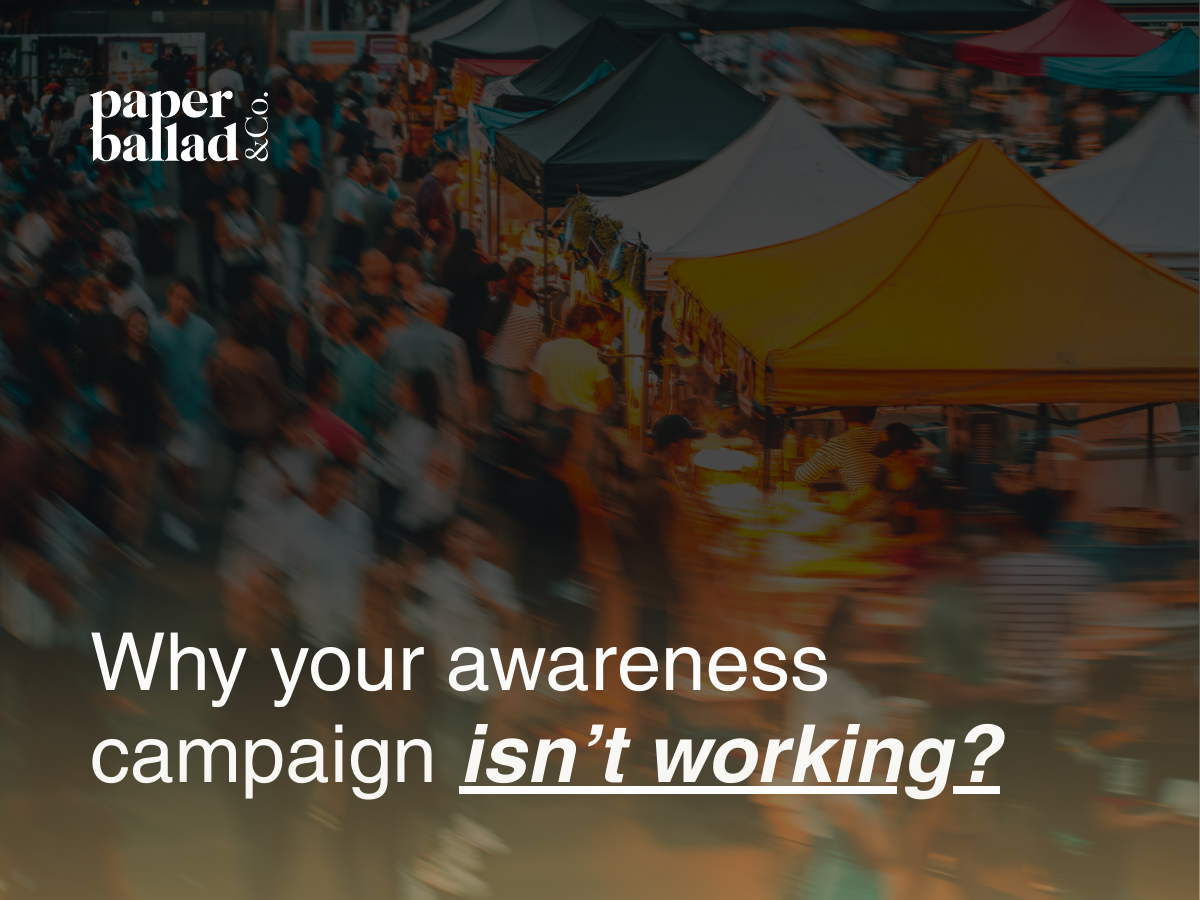 brand awareness visual showing a busy outdoor market scene with many people moving through rows of colourful tents. The crowd is intentionally blurred to create a sense of motion and noise, symbolising how brands can get lost in crowded spaces and struggle to stand out or be noticed.
