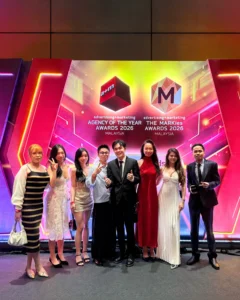 Creative Agency Malaysia - Paperballad Team showing a group of eight team members poses together at the Agency of the Year Awards and MARKies Awards Malaysia event, smiling in formal attire in front of a vibrant awards backdrop that celebrates the achievements of a creative agency in Malaysia.
