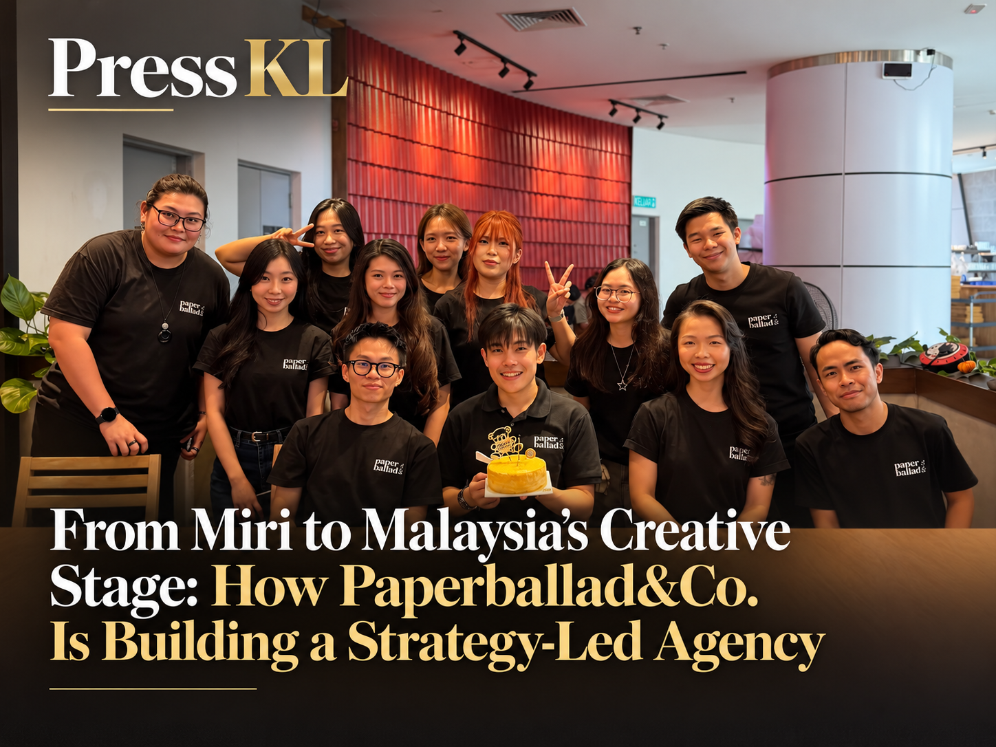 A featured article image showing the Paperballad&Co. team posing together indoors in matching black shirts, with one team member holding a small celebration cake. The Press KL logo appears at the top left, while the headline “From Miri to Malaysia’s Creative Stage: How Paperballad&Co. Is Building a Strategy-Led Agency” is displayed in large white and gold text across the lower section.